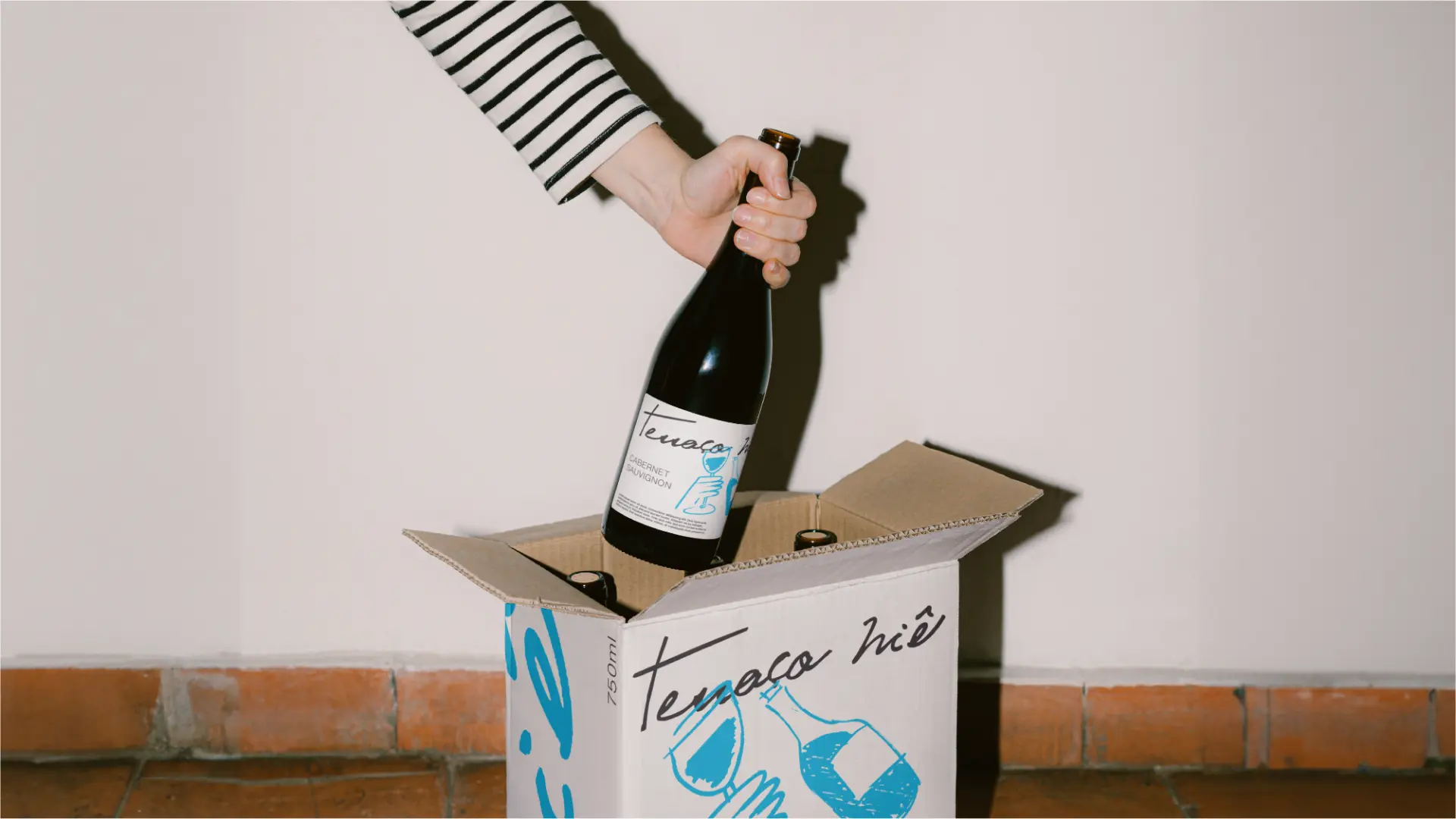 Garrafa de vinho e caixa com a identidade do Terraço Niê